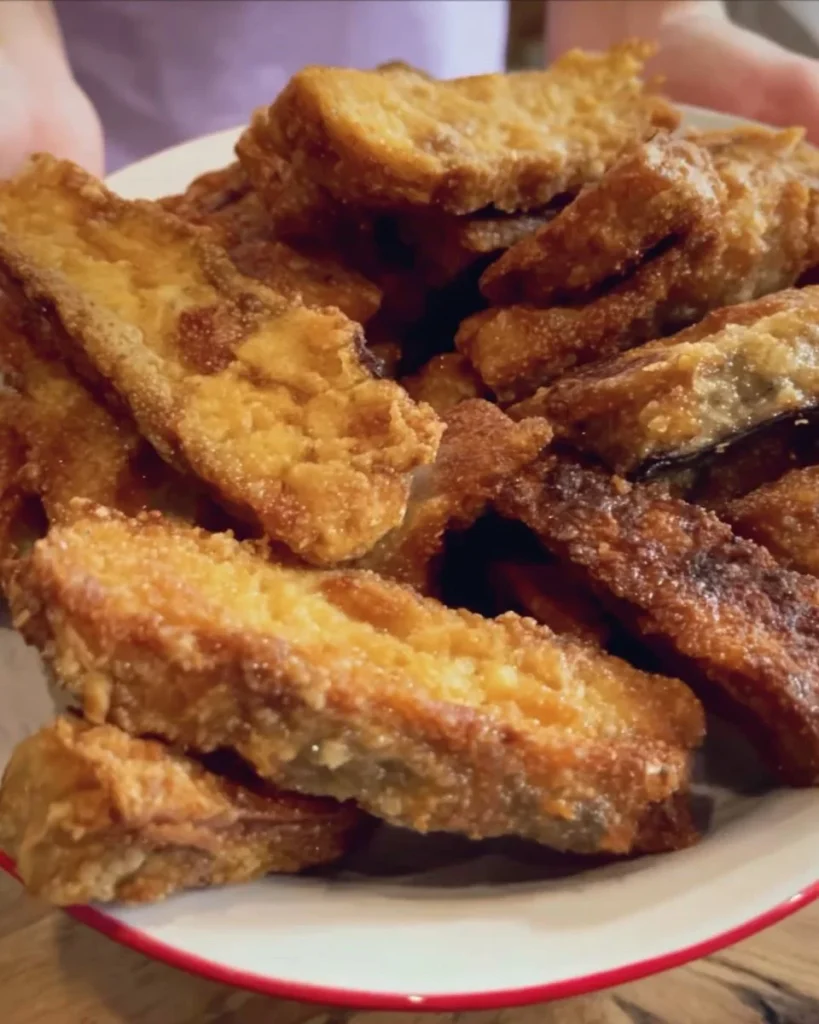 Bastoncini di melanzane croccanti serviti su un piatto colorato.