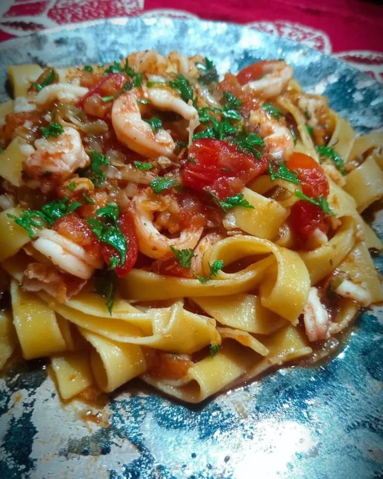 Piatto di calamarata servito con salsa di pomodoro e calamari