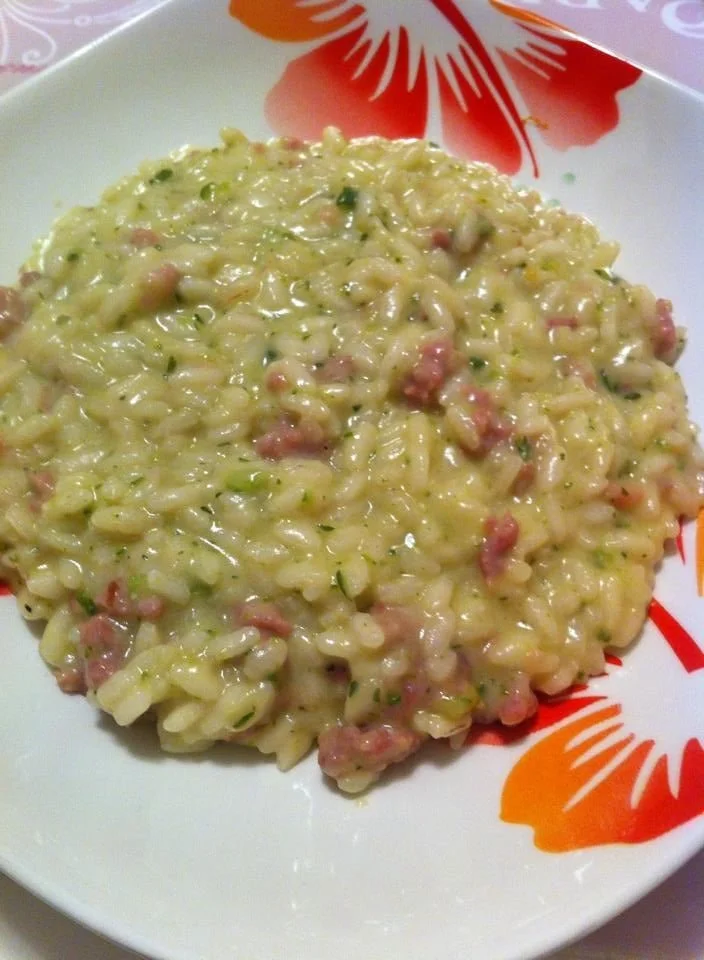 Risotto con crema di zucchine e salsiccia in un piatto gourmet