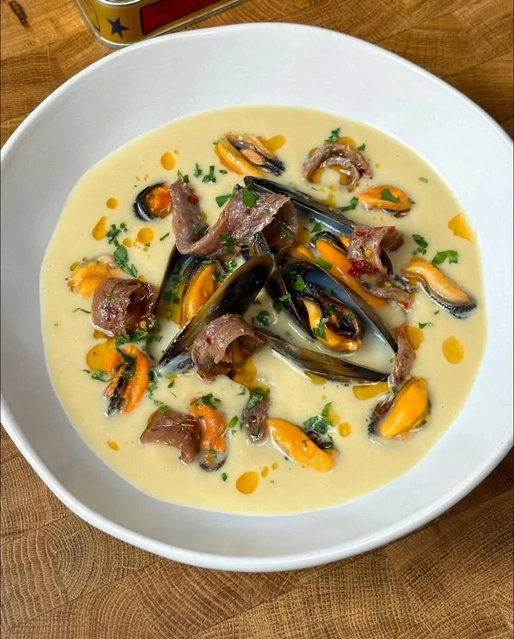 Passatina di ceci con cozze fresche e alici piccanti in un piatto appetitoso