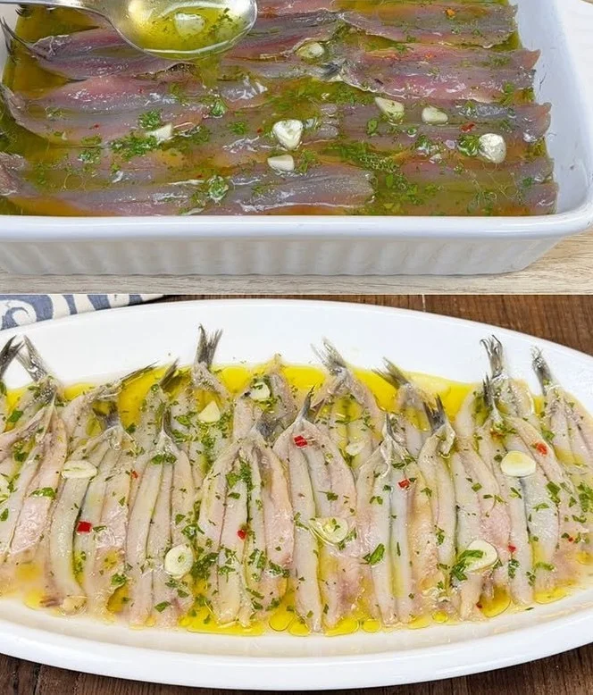 Alici marinate pronte da gustare con un contorno di limone e prezzemolo.