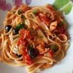 Piatto di linguine al tonno con olive, capperi e acciughe