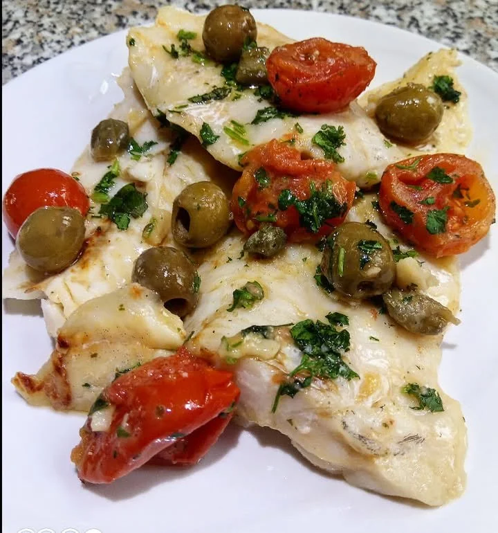 Piatto di merluzzo con pomodorini alla siciliana servito in un piatto