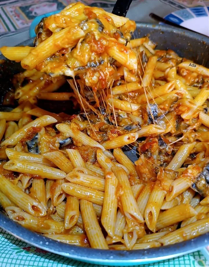Pasta con melanzane fritte e provolone affumicato in un piatto delizioso