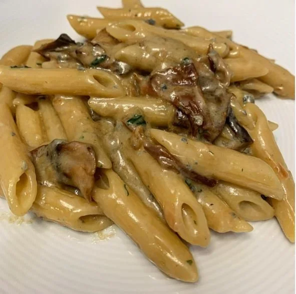 Penne Rigate Gorgonzola e Funghi Porcini serviti in un piatto elegante