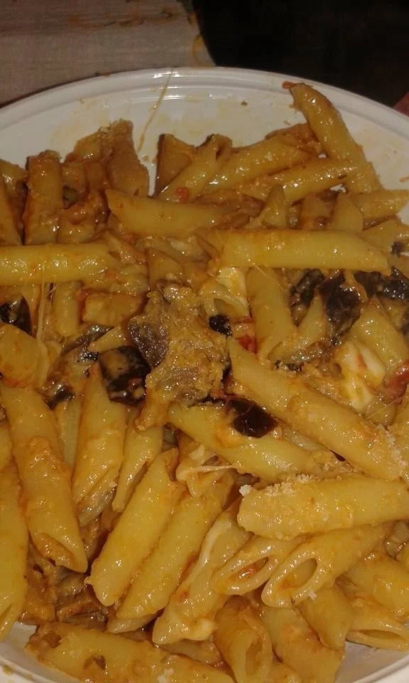 Piatto di pennette melanzane e provola con ingredienti freschi