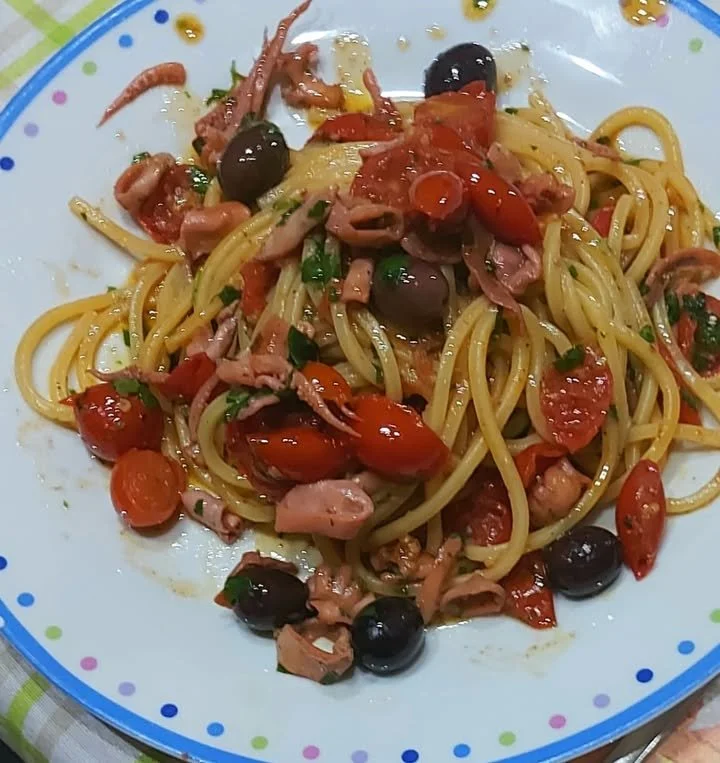 Spaghetti alla chitarra con moscardini serviti in un piatto elegante